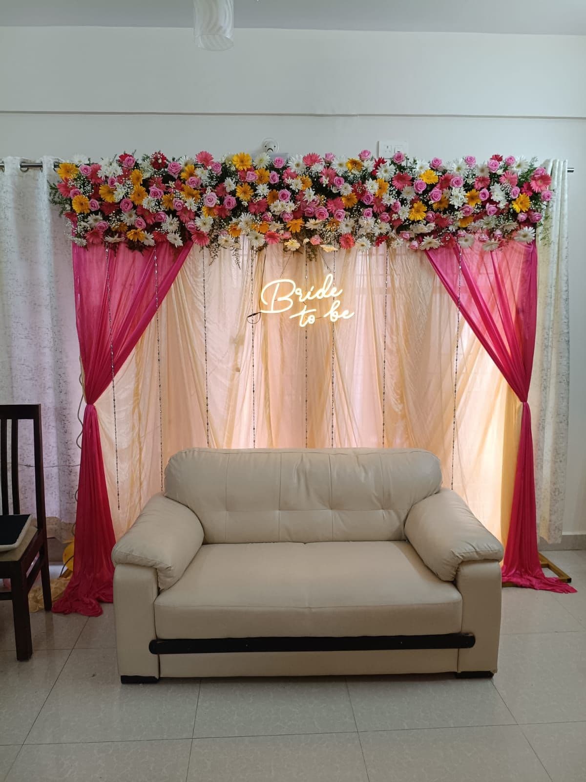 Bride-to-be backdrop with pink drapes and floral top