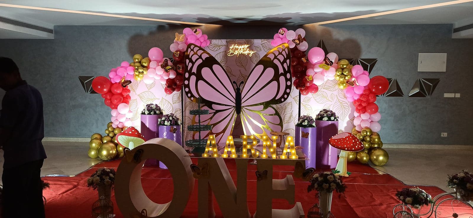 Butterfly-themed first birthday backdrop with ONE letters