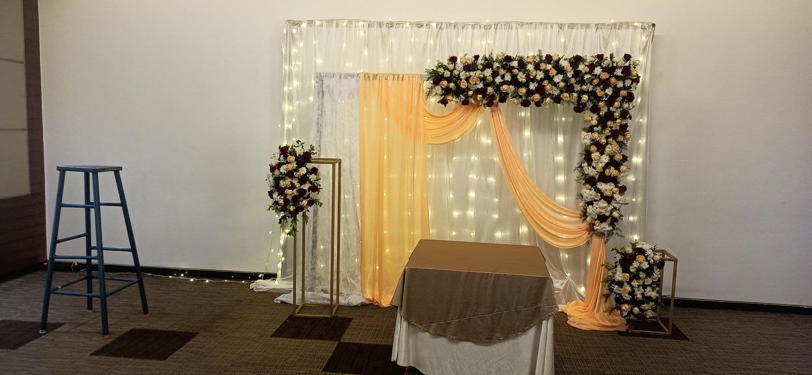Wide view of a fairy-light backdrop with floral corner