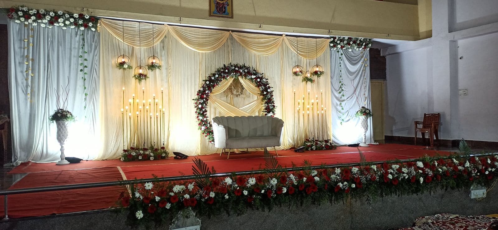 Hall stage with floral ring, sofa and red carpet