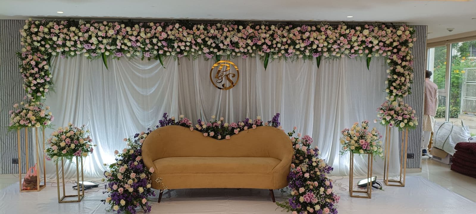 Floral engagement stage with gold sofa and rose stands