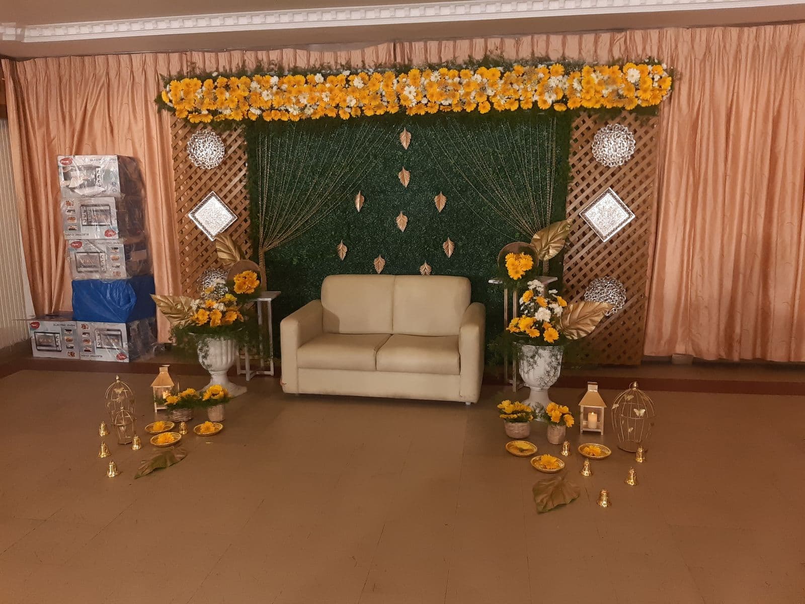 Green leaf wall with marigold top and white sofa for mehendi