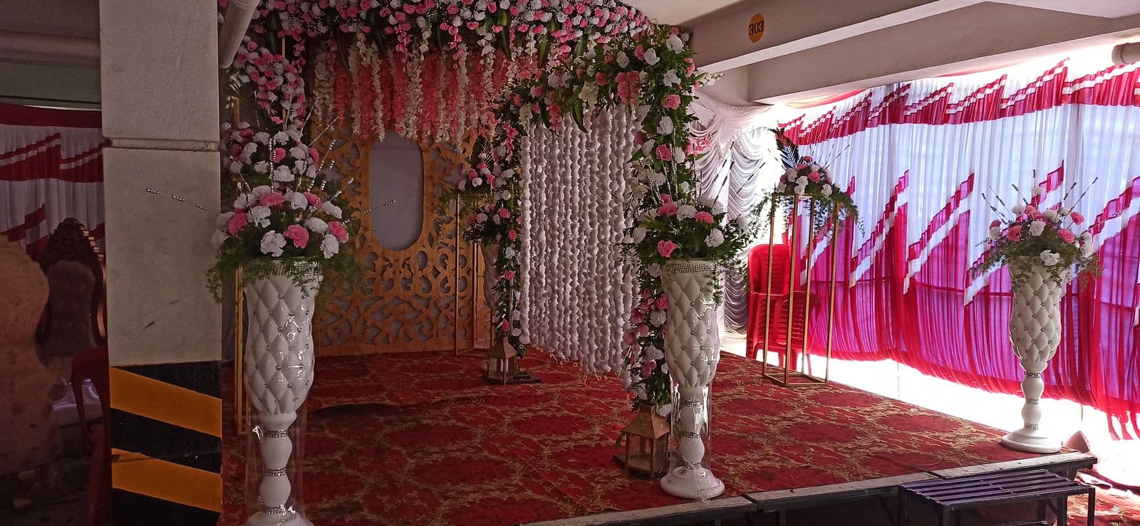 Stage with pink floral pillars and hanging florals