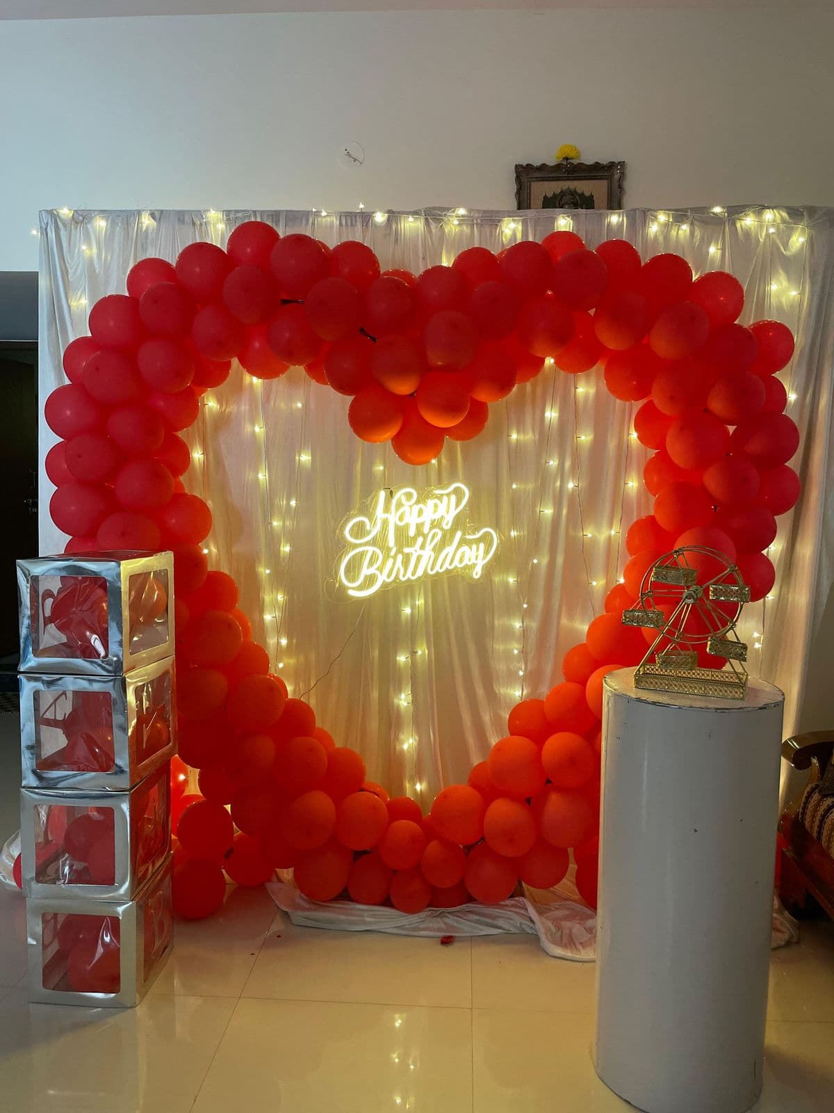 Red heart-shaped balloon frame with Happy Birthday neon and fairy lights