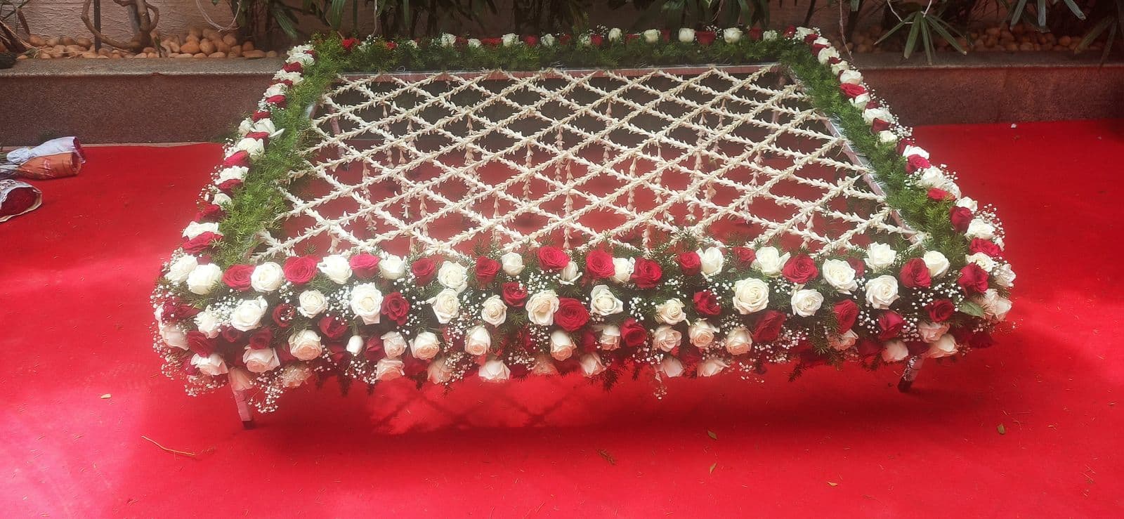 Red and white rose chadar on a red carpet