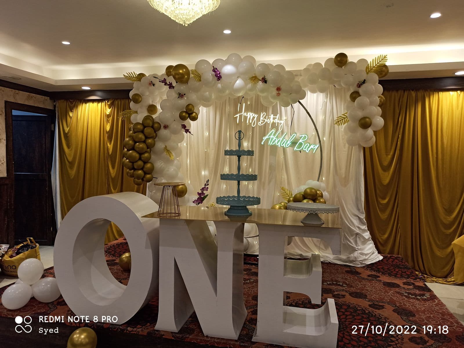 White and gold first birthday setup with ONE letters