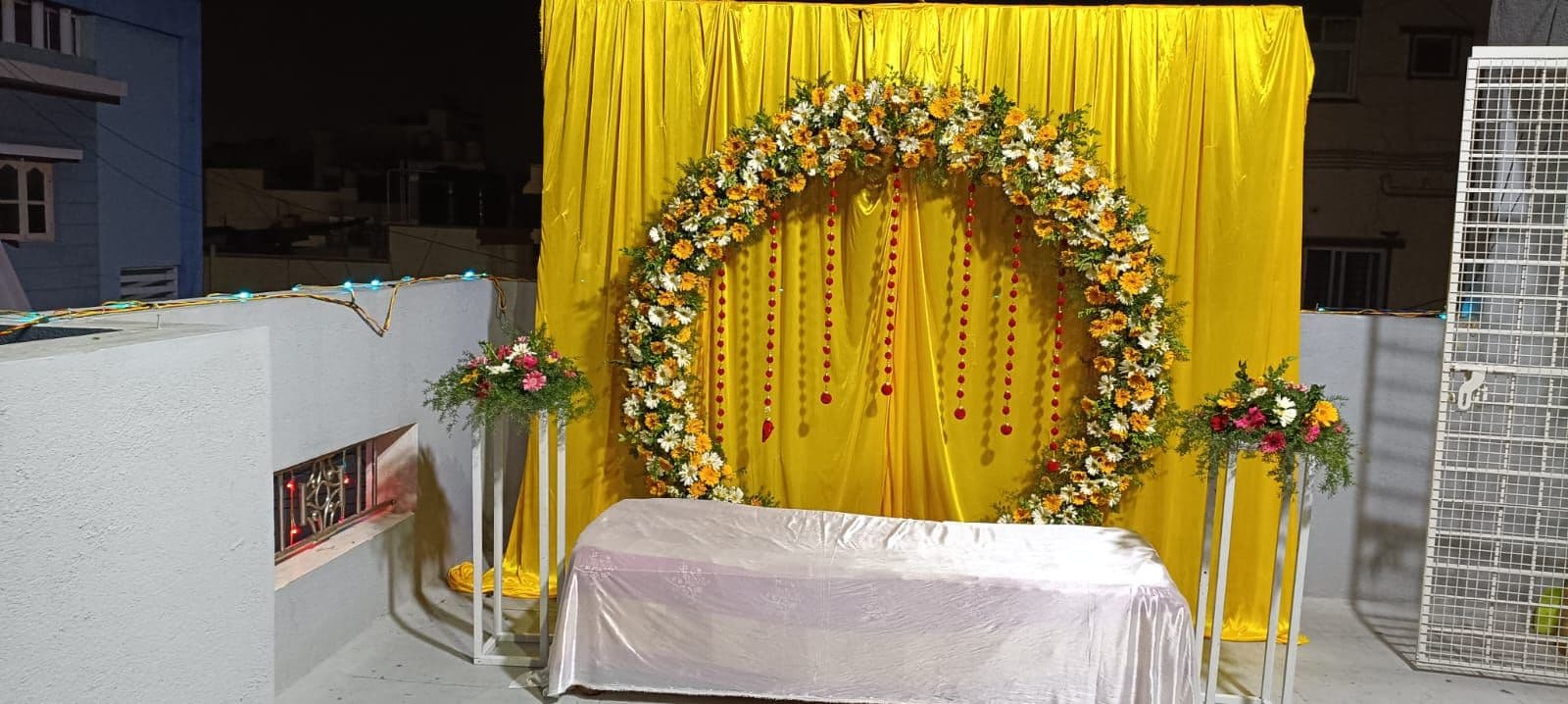 Yellow drape haldi backdrop with marigold floral ring