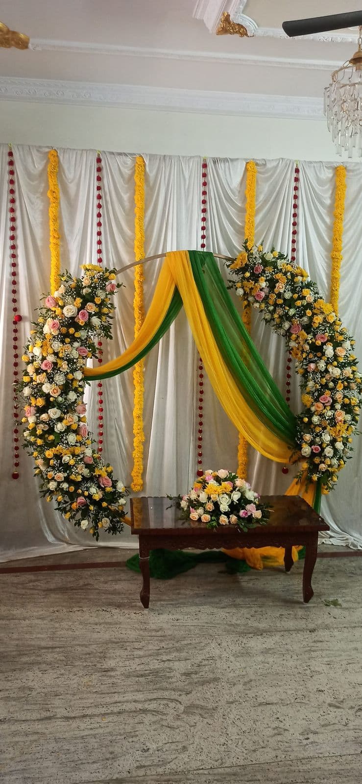 Yellow and green drape haldi backdrop with floral ring