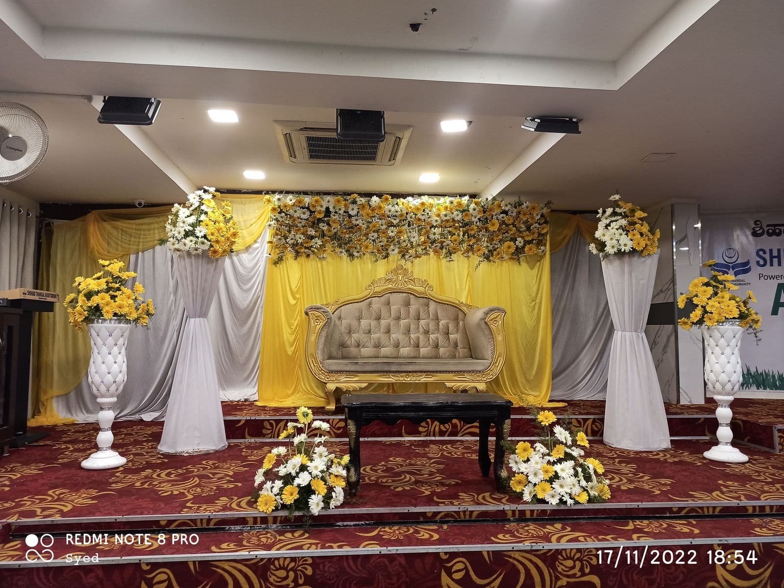 Yellow and white floral stage for a mehendi function