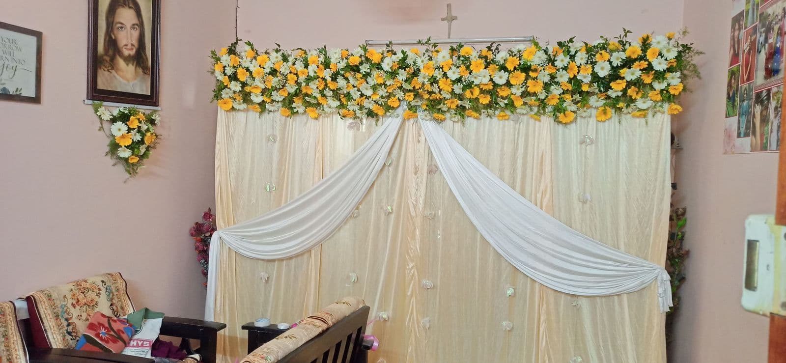 Yellow and white drape home haldi backdrop with marigold and rose top