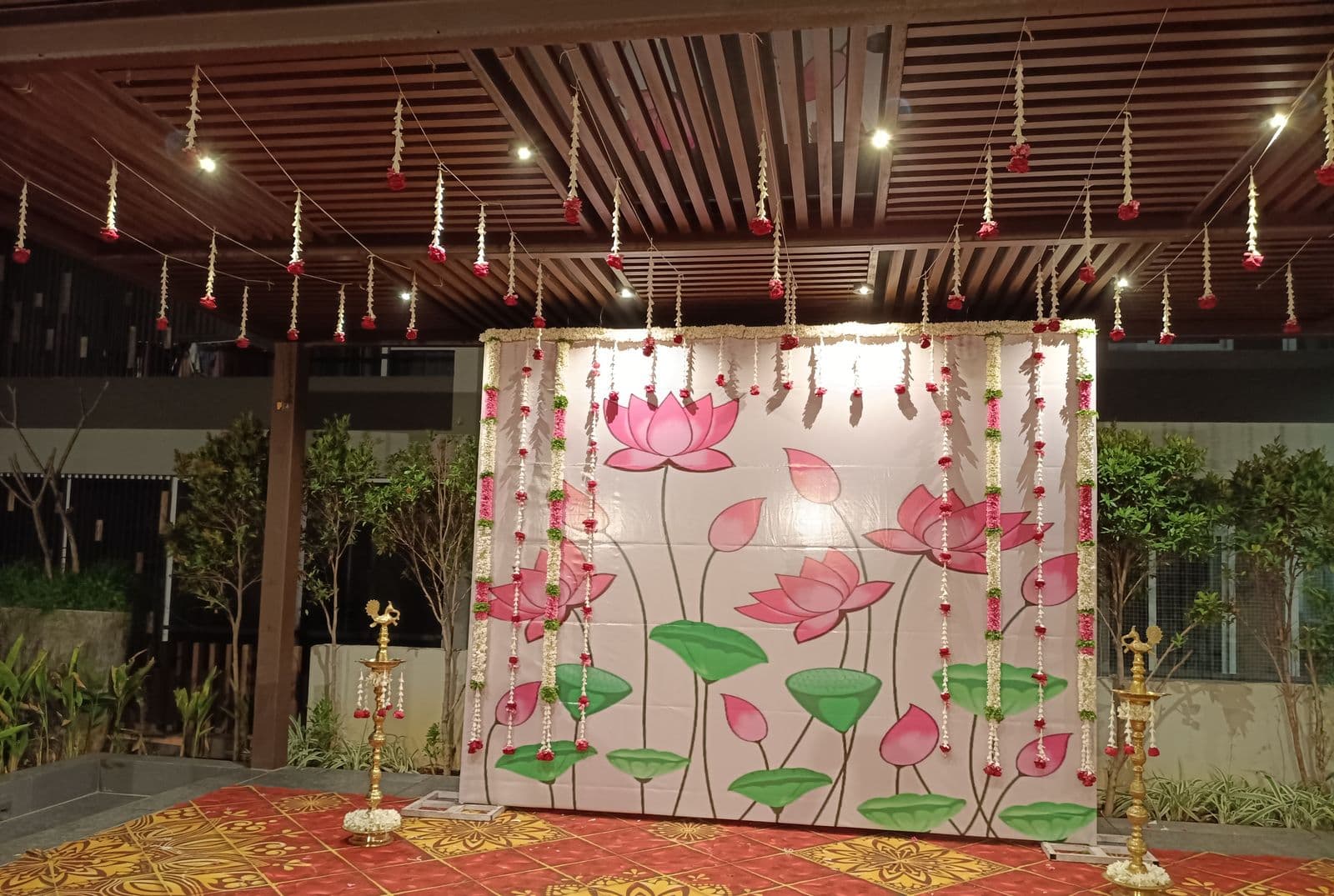 Painted lotus panel backdrop for a pooja or naming ceremony